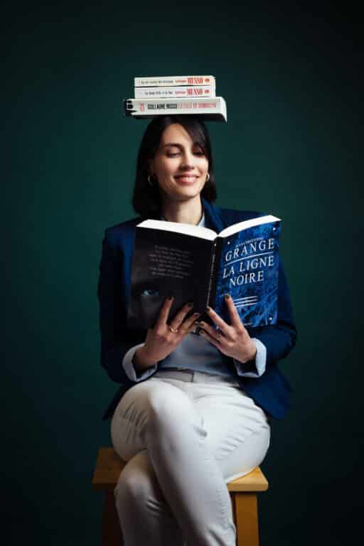 Marie Laugier, Assistante Back et Middle Office chez M Conseils : photo décalée avec des livres